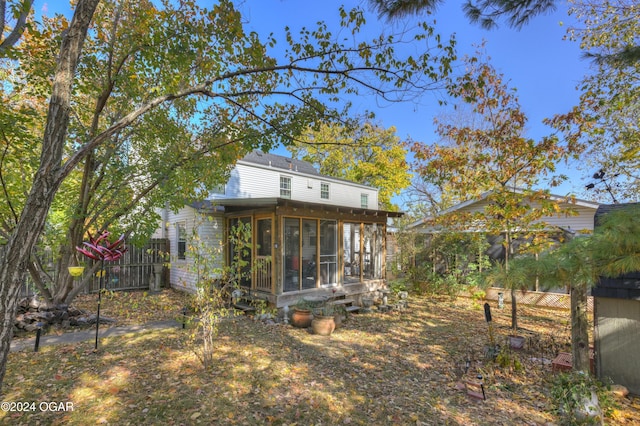 rear view of property with fence and a sunroom