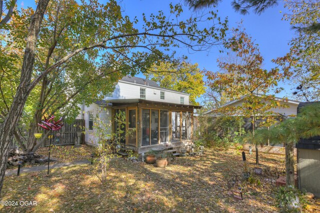 114 W F St, Joplin, MO 64801 - rear view of house featuring a sunroom and fence