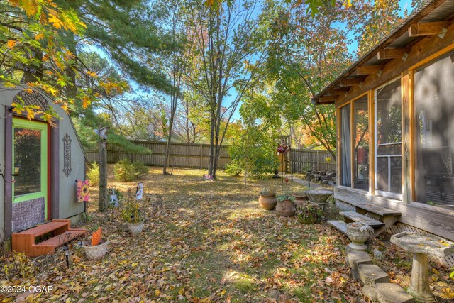 114 W F St, Joplin, MO 64801 - fenced backyard featuring a sunroom and entry steps
