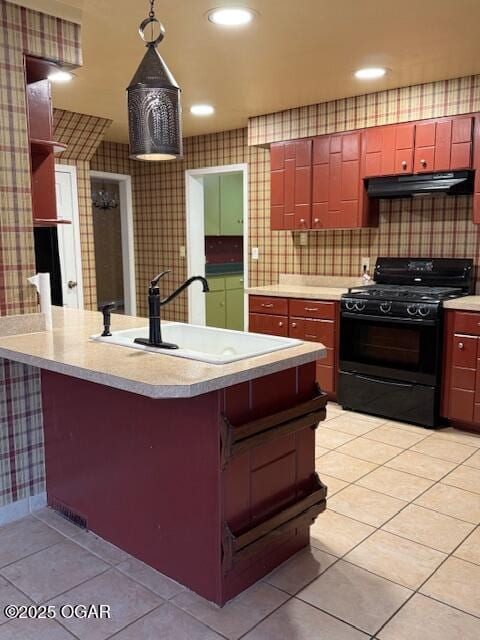 kitchen with light countertops, hanging light fixtures, gas stove, a sink, and ventilation hood