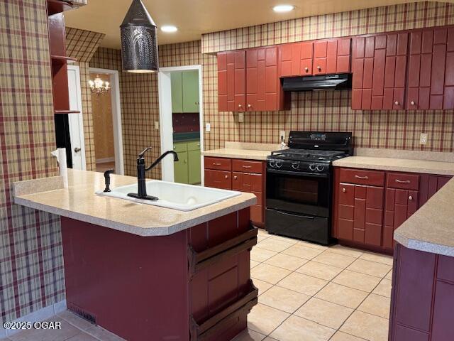 kitchen featuring black range with gas cooktop, ventilation hood, light countertops, and wallpapered walls