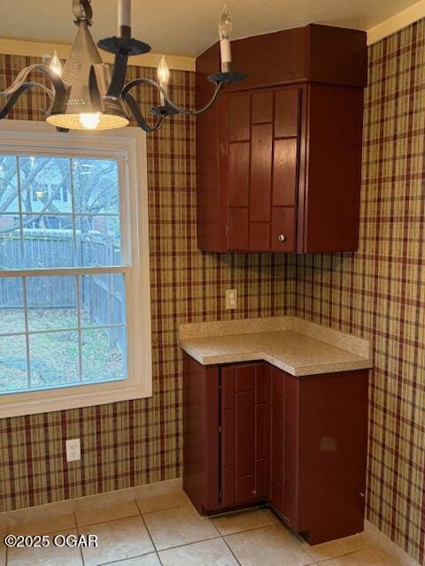 kitchen with plenty of natural light, light countertops, a notable chandelier, and light tile patterned floors