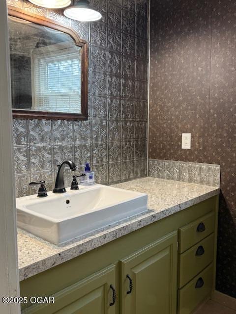 bathroom featuring vanity and wallpapered walls