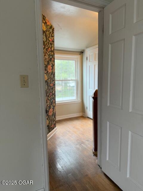 hall featuring baseboards and light wood finished floors