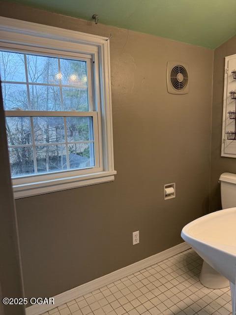 bathroom featuring a wealth of natural light, tile patterned flooring, visible vents, and baseboards