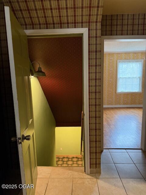 interior space with wallpapered walls, baseboards, and tile patterned floors