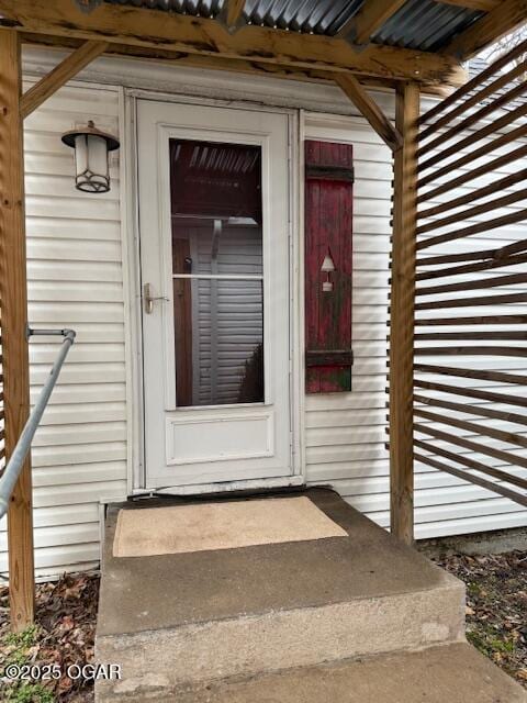 doorway to property featuring metal roof