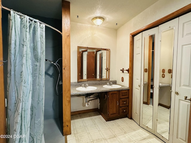 bathroom with vanity, a textured ceiling, and walk in shower