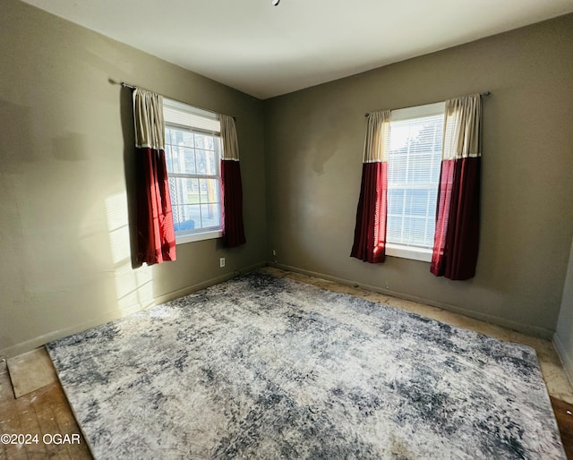 empty room with a wealth of natural light and hardwood / wood-style flooring