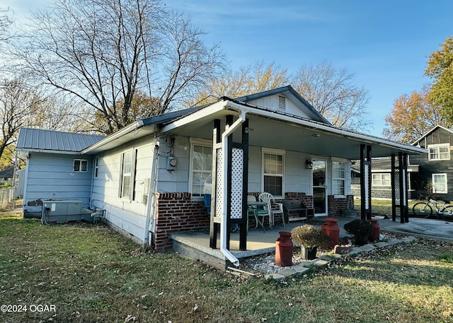 back of house featuring a porch and a yard