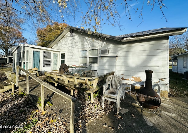 back of house with a sunroom, a wooden deck, and central AC