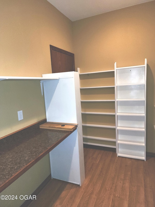 walk in closet with dark wood-type flooring