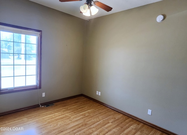 empty room with ceiling fan and light hardwood / wood-style flooring