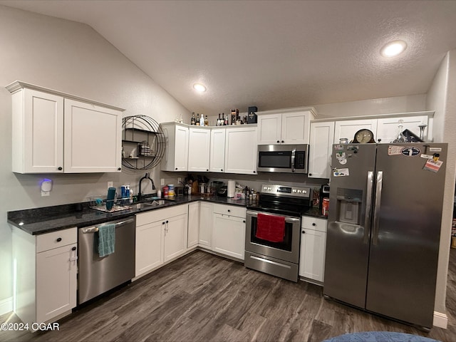 kitchen featuring sink, appliances with stainless steel finishes, vaulted ceiling, and white cabinets