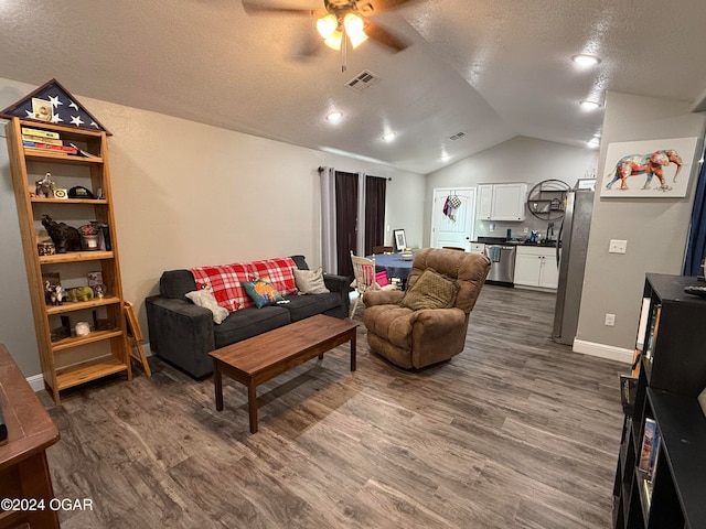 living room with dark wood-type flooring, ceiling fan, a textured ceiling, and lofted ceiling