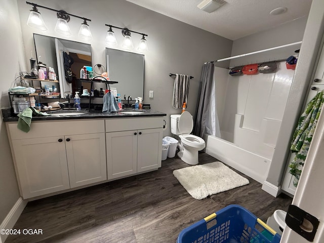 full bathroom with vanity, a textured ceiling, shower / bath combo, hardwood / wood-style flooring, and toilet