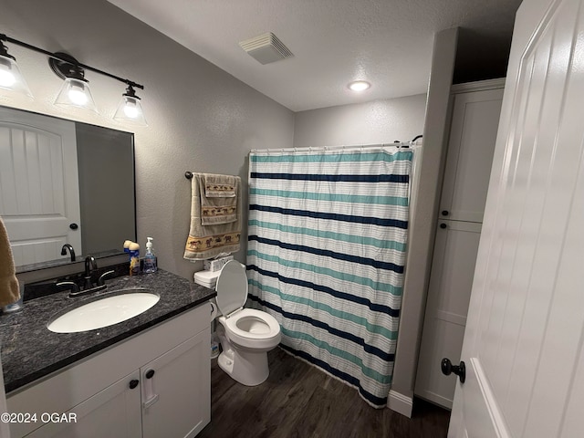 bathroom with wood-type flooring, vanity, a textured ceiling, curtained shower, and toilet