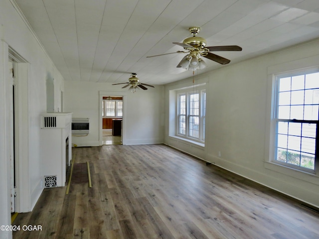 unfurnished living room featuring heating unit, hardwood / wood-style floors, and ceiling fan