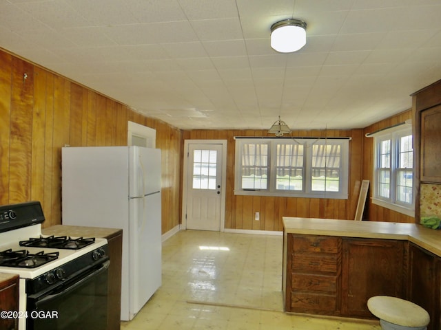 912 Chestnut Ave, Joplin, MO 64801 - kitchen with range with gas cooktop, wood walls, plenty of natural light, light flooring, and light countertops