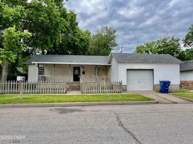 ranch-style house with a front yard, a garage, and covered porch