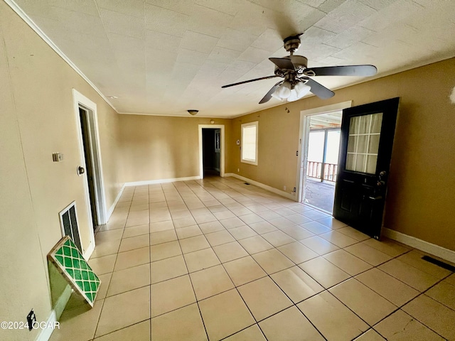 tiled spare room with ornamental molding and ceiling fan