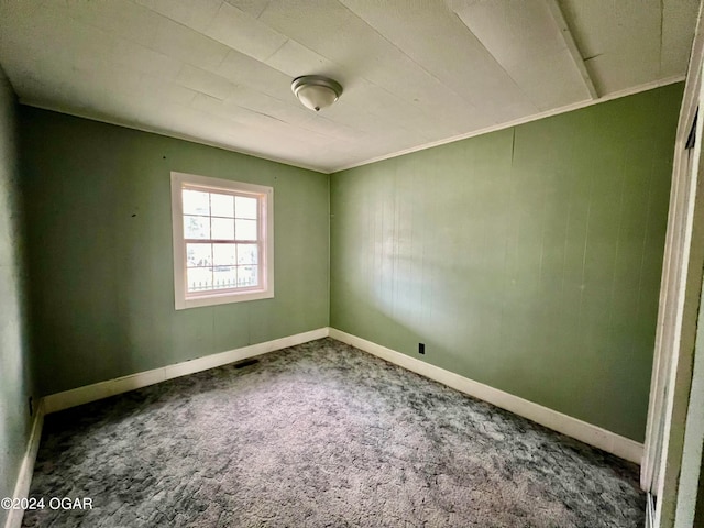 carpeted empty room featuring crown molding