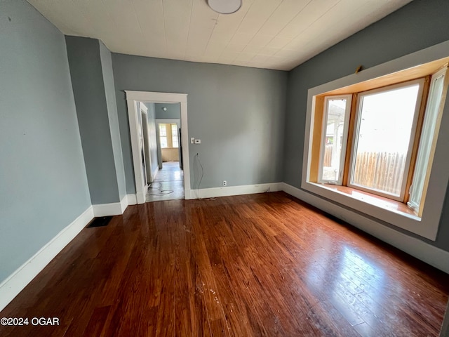 empty room with plenty of natural light and hardwood / wood-style flooring