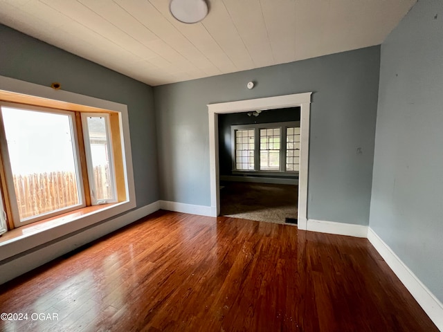 empty room with hardwood / wood-style floors and baseboard heating