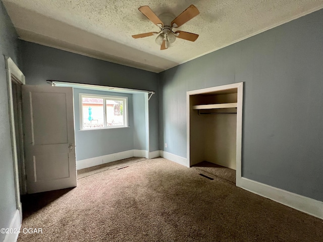 unfurnished bedroom with carpet flooring, a textured ceiling, ceiling fan, and a closet