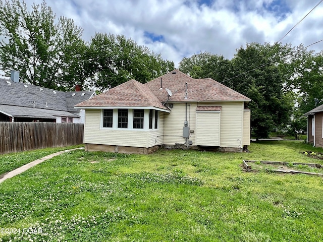 rear view of property featuring a yard