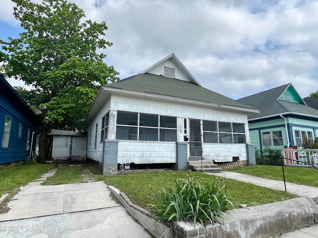 bungalow featuring a sunroom and a front yard