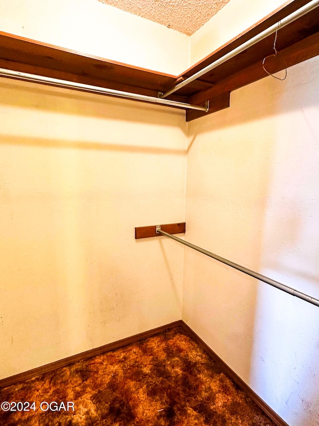 spacious closet with dark carpet