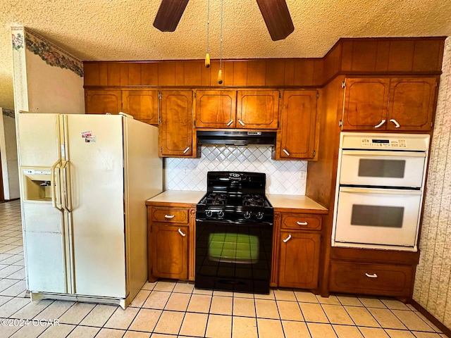 kitchen featuring ceiling fan, a textured ceiling, white appliances, decorative backsplash, and light tile patterned floors