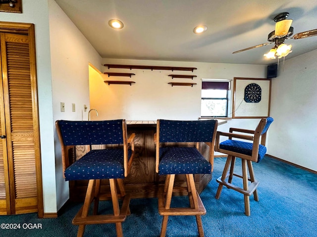 dining room with ceiling fan and dark carpet