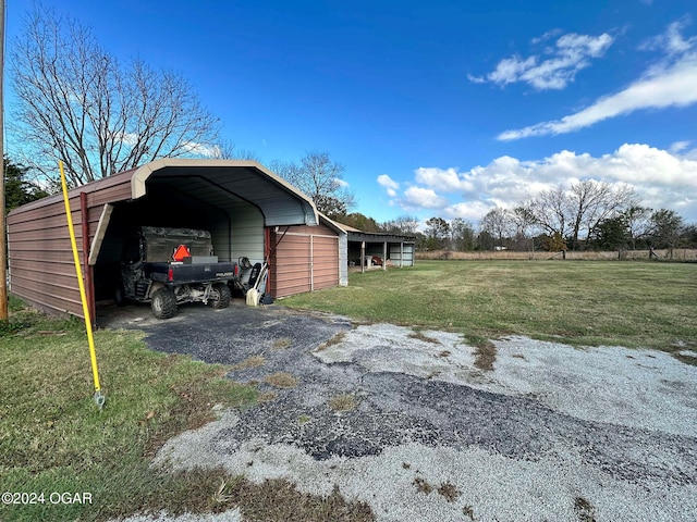 view of outbuilding featuring a yard and a carport