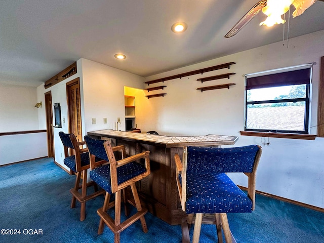 dining area featuring dark carpet and bar