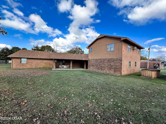 rear view of house with a lawn and a patio