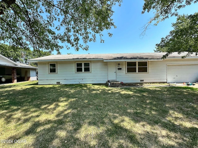 rear view of property with a lawn and a garage