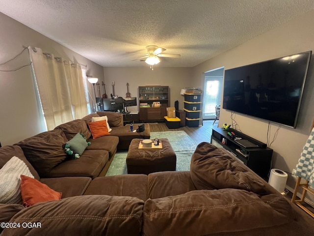 living room featuring wood-type flooring, a textured ceiling, and ceiling fan