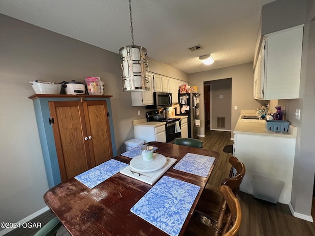 dining room featuring a textured ceiling, dark wood-type flooring, and sink