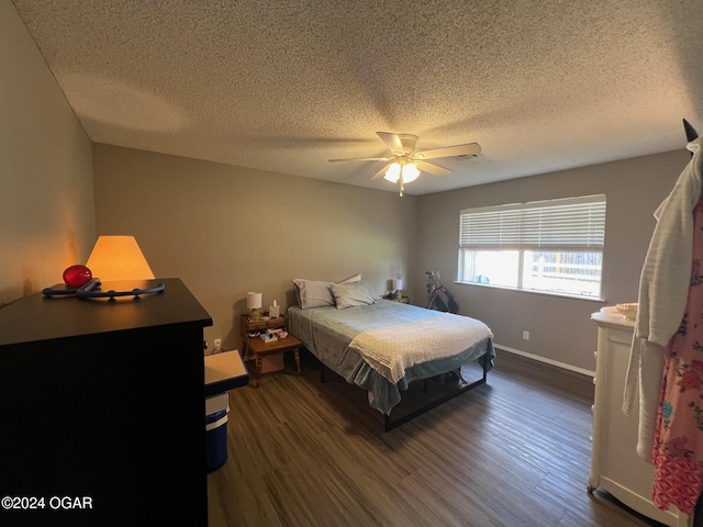 bedroom featuring ceiling fan, dark hardwood / wood-style floors, and a textured ceiling