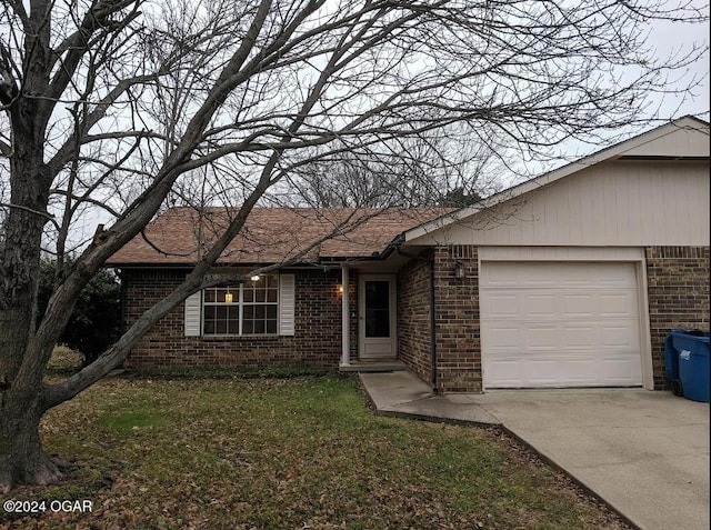 single story home featuring a garage and a front lawn