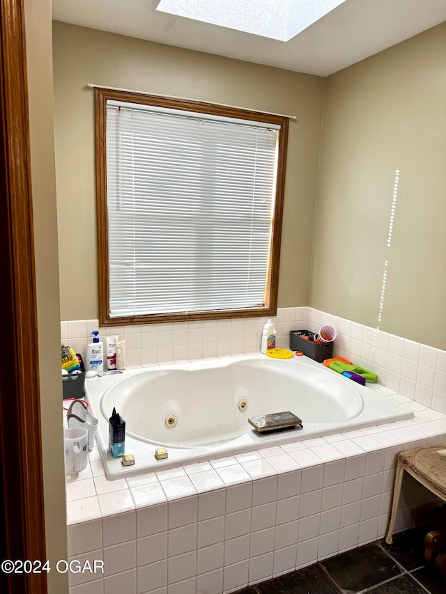 bathroom featuring tiled bath, tile patterned flooring, and a skylight