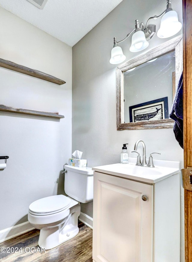 bathroom with hardwood / wood-style floors, vanity, a textured ceiling, and toilet