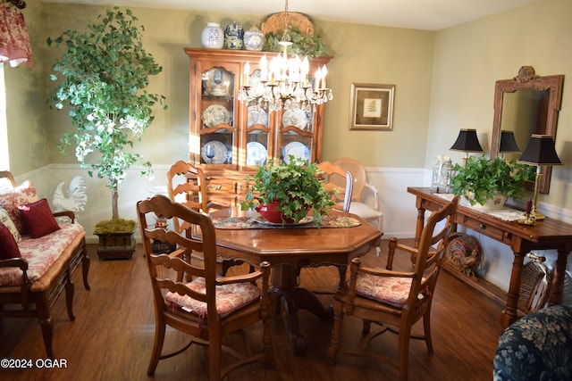 dining space featuring dark wood-type flooring and a notable chandelier