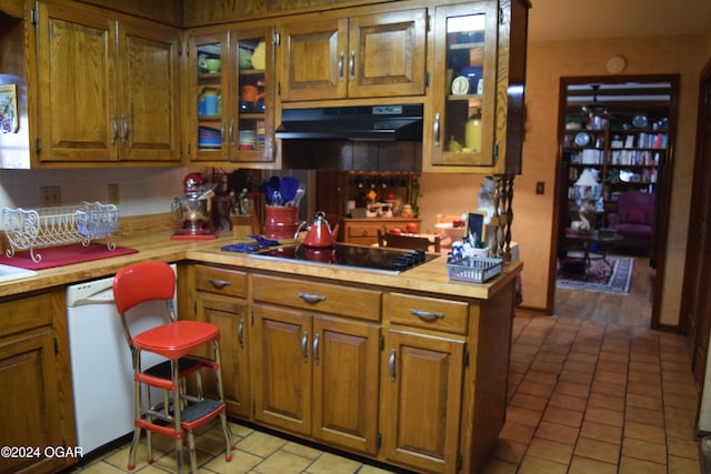 kitchen featuring black electric cooktop, decorative backsplash, dishwasher, and light tile patterned floors