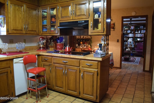 kitchen featuring dishwasher, exhaust hood, gas stovetop, tasteful backsplash, and kitchen peninsula