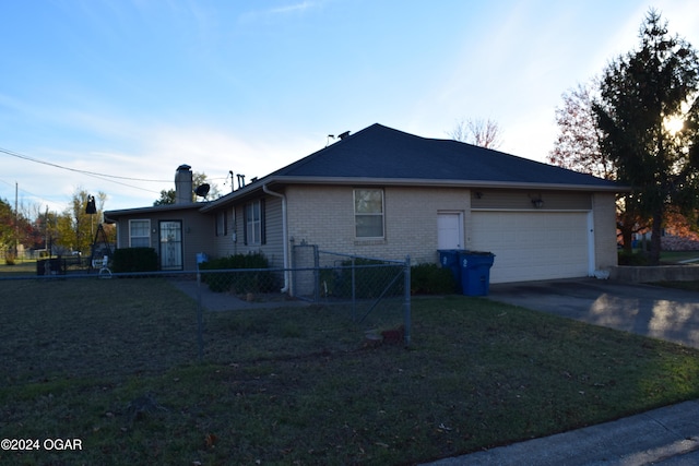 view of side of property featuring a garage and a yard