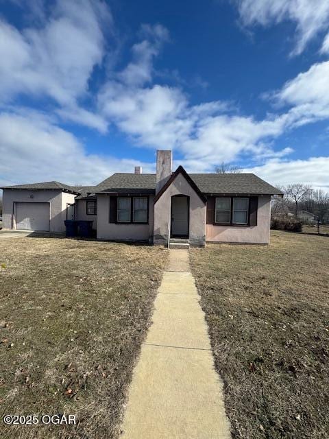 single story home featuring a garage and a front yard