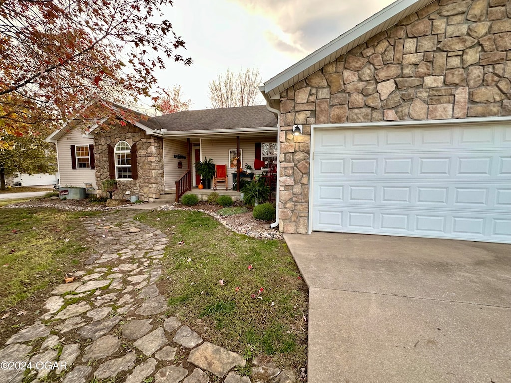 ranch-style home featuring a porch and a garage